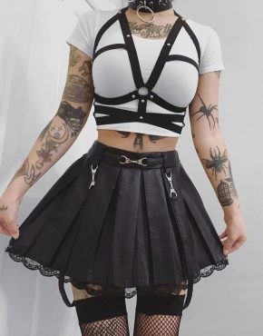 tattooed gothic girl dressed in the skirt and open bra harness