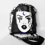 This purse depicts the face of punk\gothic girl with choker & moon details, decorated with detachable stylized “earrings” with blue crystals.