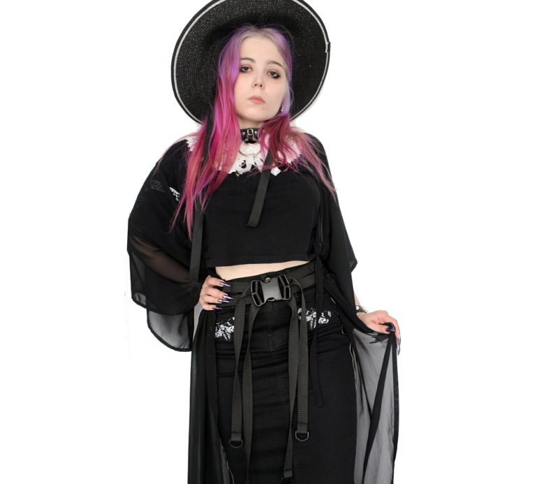 Gothic girl with colored hair in black dress wearing nylon harness belt