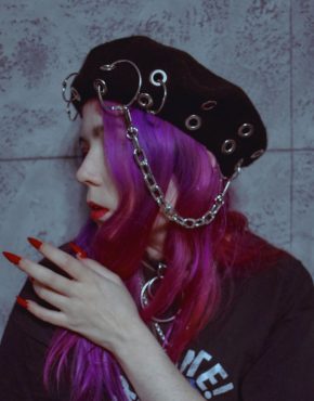 pastel goth girl in black woolen beret with chain