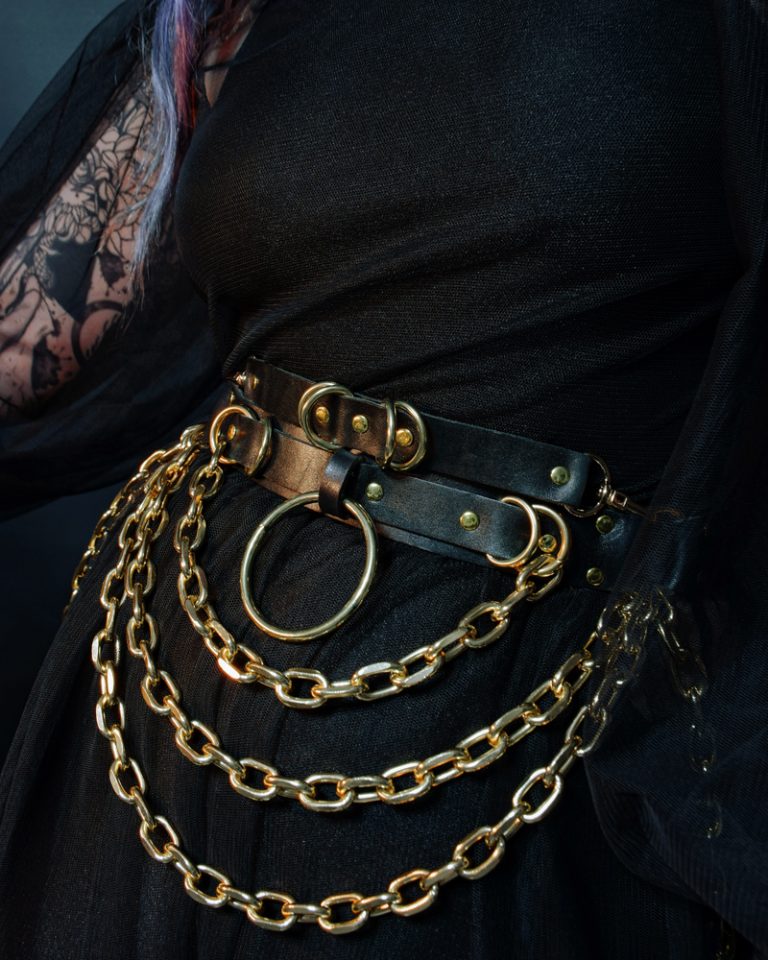 tattooed goth girl wearing golden chains belt